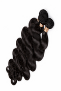 Three bundles of black hair extensions on a white background
