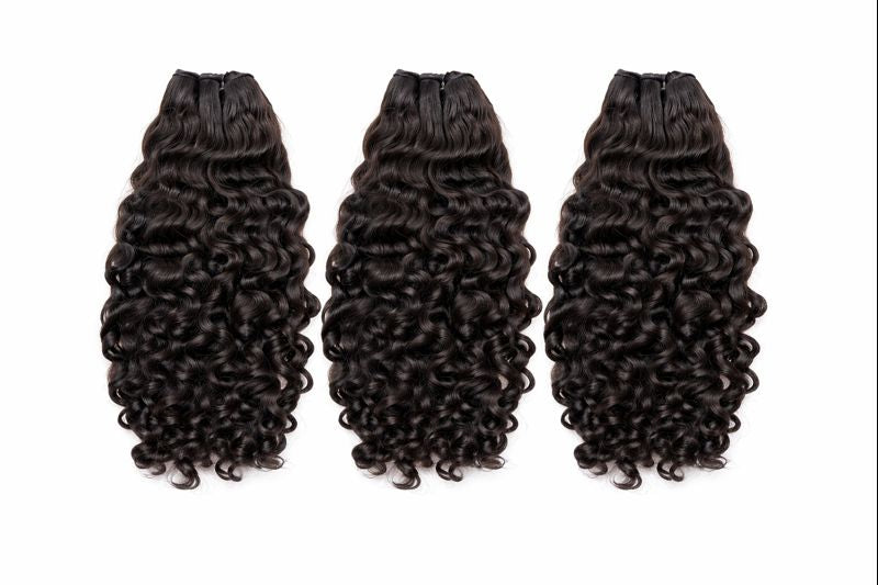 Three bundles of curly hair extensions on a white background